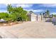 Long driveway leading to a large garage in this single story home, surrounded by mature landscaping at 3684 Mooncrest Cir, Las Vegas, NV 89129