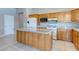 Open kitchen features wood cabinetry, granite countertops, a center island, and stainless steel appliances at 3684 Mooncrest Cir, Las Vegas, NV 89129