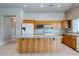 Open kitchen featuring wood cabinetry, granite countertops, a center island, and stainless steel appliances at 3684 Mooncrest Cir, Las Vegas, NV 89129