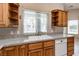 Kitchen features wood cabinets, granite countertops, a stainless steel faucet, white double sink, and a dishwasher at 3684 Mooncrest Cir, Las Vegas, NV 89129