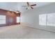 Bright living room with accent wall, carpet, and two ceiling fans at 3684 Mooncrest Cir, Las Vegas, NV 89129