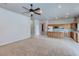 Spacious open floor plan, living room and kitchen with carpet, neutral paint, tile flooring, and modern appliances at 3684 Mooncrest Cir, Las Vegas, NV 89129