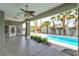 Covered patio features a ceiling fan and ample space overlooking a sparkling pool and swaying palm trees at 3684 Mooncrest Cir, Las Vegas, NV 89129
