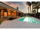 Gorgeous in-ground pool with a sun-soaked deck and covered outdoor area, framed by palm trees at 3684 Mooncrest Cir, Las Vegas, NV 89129