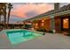 Backyard pool area featuring a sparkling pool, covered patio, and palm trees at sunset at 3684 Mooncrest Cir, Las Vegas, NV 89129