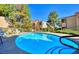 Sparkling community pool with blue water, relaxing lounge chairs, and lush greenery around the perimeter at 3740 Desert Marina Dr # 12, Laughlin, NV 89029