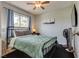 Cozy bedroom with a full-sized bed, a window with curtains, wall art, and a tower fan at 3886 Green Leaf Dr, Las Vegas, NV 89120