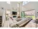 Bright living room with soaring ceilings, fireplace, large sectional, and seamless indoor/outdoor flow to backyard at 421 Malpaso St, Las Vegas, NV 89138