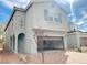 Light-grey two-story house with an open garage and desert-landscaped front yard with an arched entryway at 4274 Tarim St, Las Vegas, NV 89147