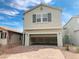 Two-story home with an open garage and brick driveway, with a light-grey color scheme and shuttered windows at 4274 Tarim St, Las Vegas, NV 89147