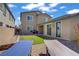 Spacious backyard featuring an artificial grass lawn, stone-paved patio, and well-kept landscaping at 4436 Mural Glen Ct, North Las Vegas, NV 89084