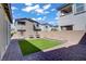 Backyard featuring a cozy artificial grass lawn, stone-paved patio, and a well-maintained brick perimeter at 4436 Mural Glen Ct, North Las Vegas, NV 89084