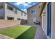 This backyard features a well-manicured artificial lawn, stone-paved patio and block-wall perimeter at 4436 Mural Glen Ct, North Las Vegas, NV 89084