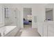 Bright bathroom with a walk-in shower and glass door, leading to a bedroom with a comfortable bed at 4436 Mural Glen Ct, North Las Vegas, NV 89084