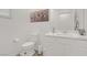 Bathroom with white cabinets, toilet, sink, mirror and zebra artwork at 4436 Mural Glen Ct, North Las Vegas, NV 89084