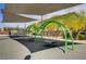 Community playground with swings and seating areas under a shade canopy at 4436 Mural Glen Ct, North Las Vegas, NV 89084