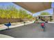 Community playground offers a slide and spring toys under a shaded structure, surrounded by greenery at 4436 Mural Glen Ct, North Las Vegas, NV 89084