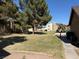 Well-maintained backyard featuring a lush lawn, mature trees, and access to nearby buildings at 4670 Tracylynn Ln, Las Vegas, NV 89121