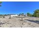Wide shot of a lot with desert landscape, a house, and a detached garage under a clear blue sky at 481 Jarvis Rd, Pahrump, NV 89060