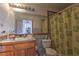 Bathroom features a large mirror, wooden vanity and shower with patterned curtain at 481 Jarvis Rd, Pahrump, NV 89060