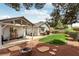 A backyard features desert landscaping, green grass, and a firepit for relaxing outdoors at 4813 Canadian Dr, Las Vegas, NV 89130
