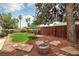 Enjoy this backyard with a firepit, desert landscaping, and beautiful green trees at 4813 Canadian Dr, Las Vegas, NV 89130