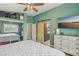 This bedroom features green walls, a sliding barn door to the bathroom, and a large TV at 4813 Canadian Dr, Las Vegas, NV 89130