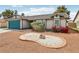 Well-maintained single-story home with decorative rock landscaping, flowers, and a blue garage door at 4813 Canadian Dr, Las Vegas, NV 89130