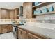 Well-equipped kitchen featuring wooden cabinets, modern countertops, stainless steel appliances, and stylish backsplash at 4813 Canadian Dr, Las Vegas, NV 89130