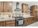 Modern kitchen with stainless steel appliances, wooden cabinetry, sleek countertops, and open shelving at 4813 Canadian Dr, Las Vegas, NV 89130
