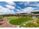Expansive backyard with a lush lawn, putting green and mature landscape at 5120 Lone View Pl, Las Vegas, NV 89149