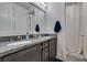 Bathroom featuring double vanity, granite countertop, and shower with tiled surround at 5120 Lone View Pl, Las Vegas, NV 89149