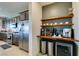 Kitchen area featuring stainless steel appliances, dark cabinetry, granite countertops, and a beverage bar at 5120 Lone View Pl, Las Vegas, NV 89149