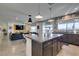 Open-concept kitchen with a large island, granite counters, seating, and view into the living room at 5120 Lone View Pl, Las Vegas, NV 89149