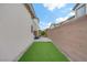 This backyard features a patch of low-maintenance artificial turf next to a private walkway at 525 Monarch Ridge Ct, North Las Vegas, NV 89084