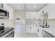 Bright kitchen features stainless steel appliances, quartz countertops, and white cabinets at 5867 Bunch St, Las Vegas, NV 89122