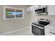 Well-lit kitchen features stainless steel appliances, white cabinets, and tile floors at 5867 Bunch St, Las Vegas, NV 89122