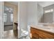 Bathroom with wood cabinets, vanity, and tiled floor leading to bedroom with ceiling fan at 5903 Karnes Ranch Ave, Las Vegas, NV 89131