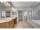 Bright bathroom featuring dual sinks, walk-in shower, soaking tub, and a spacious walk-in closet at 5903 Karnes Ranch Ave, Las Vegas, NV 89131