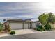 Single-story home featuring a three-car garage, desert landscaping, and a stylish tile roof at 5903 Karnes Ranch Ave, Las Vegas, NV 89131