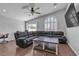 Relax in this living room, featuring an arched window, ceiling fan, and dark wood floors at 5965 Sierra Medina Ave, Las Vegas, NV 89139