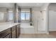 Bathroom with a soaking tub, glass shower, and a double sink vanity at 626 Taliput Palm Pl, Henderson, NV 89011