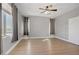 Bright bedroom featuring two windows with gray curtains and light wood flooring at 626 Taliput Palm Pl, Henderson, NV 89011