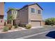 Two-story home featuring a two-car garage and simple xeriscaped yard with bushes and a young tree at 626 Taliput Palm Pl, Henderson, NV 89011
