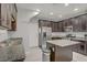 Modern kitchen with dark brown cabinets, stainless appliances, granite countertops and island, with an open floorplan at 626 Taliput Palm Pl, Henderson, NV 89011