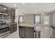 Modern kitchen island overlooks a living area featuring hardwood floors, gray walls, and ample natural light at 626 Taliput Palm Pl, Henderson, NV 89011