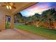 Covered patio with ceiling fan overlooking a spacious backyard with lush lawn and mature landscaping at 6345 Cinnabar Ridge Ave, Las Vegas, NV 89130