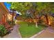 Landscaped backyard with lush lawn, mature trees, and a charming garden, perfect for outdoor relaxation at 6345 Cinnabar Ridge Ave, Las Vegas, NV 89130