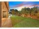 Backyard with a well-manicured lawn, bordered by tropical landscaping and a charming fence at 6345 Cinnabar Ridge Ave, Las Vegas, NV 89130
