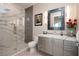 Modern bathroom with marble shower, stylish vanity and decorative mirror at 661 Dragon Peak Dr, Henderson, NV 89012